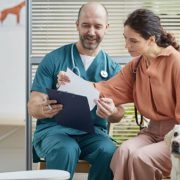Vet talking with dog owner in the clinic